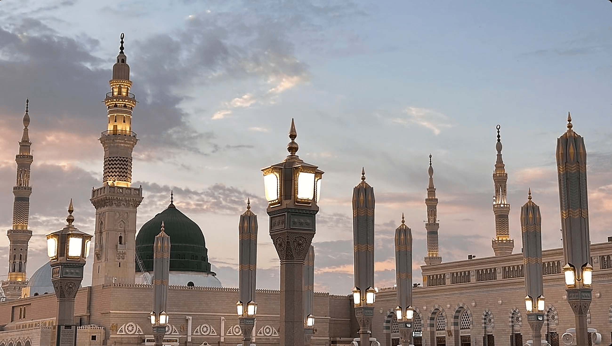 Al-Masjid an-Nabawi in Madinah at dusk with golden lanterns
